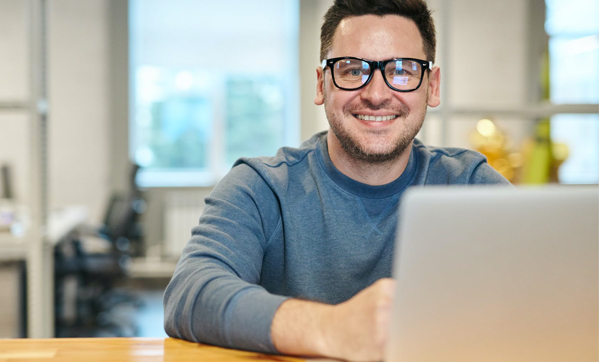 Man with Glasses with a computer in front